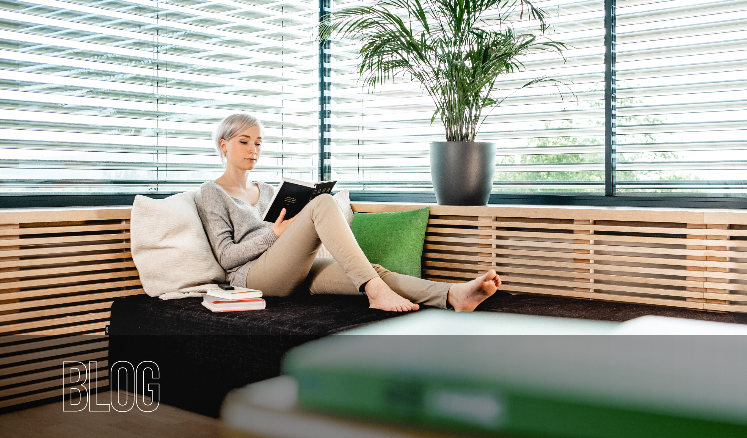A woman sits relaxed on a sofa in a stylish smart home living room - Blog